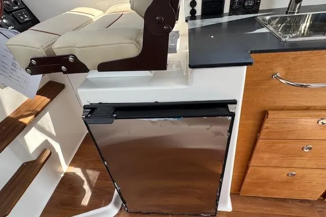 Slide: The Image of 2026 Cutwater C-288 Coupe interior with seating, stainless steel fridge, and wooden cabinetry. - 27