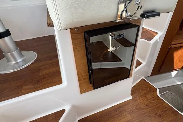 Slide: The Image of Interior of 2026 Cutwater C-288 Coupe featuring a compact refrigerator and wooden flooring. - 28