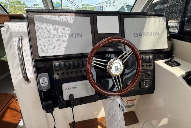 Slide: The Image of 2026 Cutwater C-288 Coupe helm with Garmin navigation system and wooden steering wheel. - 29