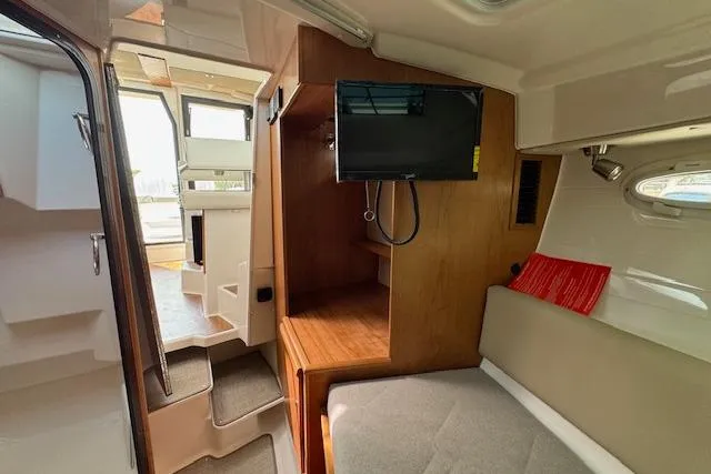 Slide: The Image of 2026 Cutwater C-288 Coupe interior with TV, seating, and wooden cabinetry. - 33