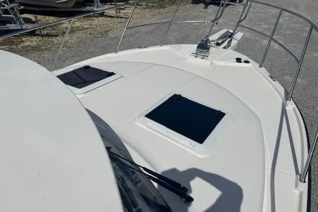Slide: The Image of 2026 Cutwater C-288 Coupe boat deck with hatches and railing in a marina setting. - 41