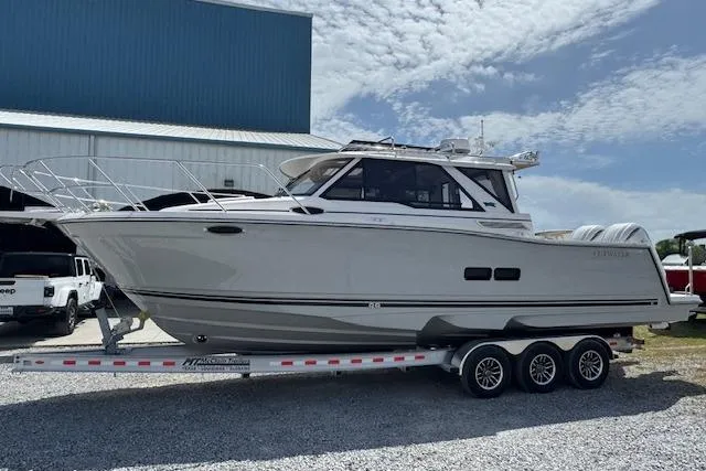 Slide: The Image of 2026 Cutwater C-288 Coupe boat on trailer, parked outdoors under a partly cloudy sky. - 5
