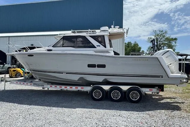 Slide: The Image of 2026 Cutwater C-288 Coupe boat on trailer, parked outdoors near a blue building. - 6