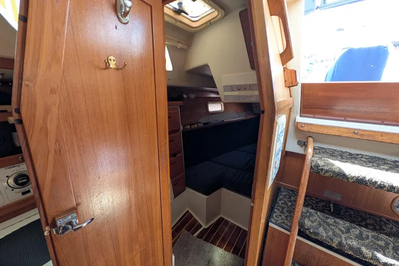 Slide: The Image of Interior cabin of a 1995 Catalina 36 MkII sailboat with wooden cabinetry and cozy sleeping area. - 21