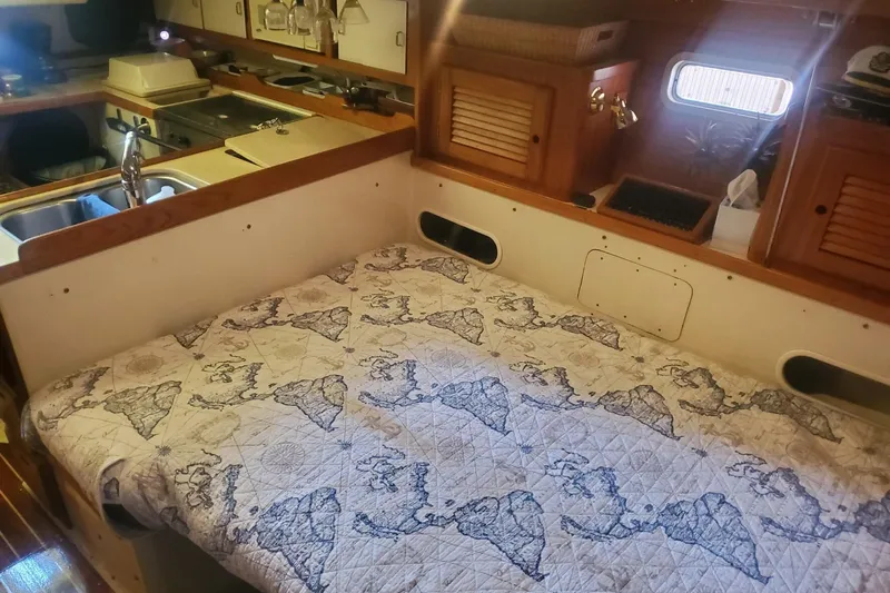 Slide: The Image of Interior cabin of a 1995 Catalina 36 MkII sailboat with wooden cabinetry and cozy sleeping area. - 24