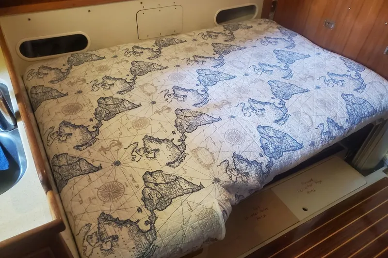 Slide: The Image of Interior of a 1995 Catalina 36 MkII sailboat, featuring wooden cabinetry and cozy sleeping quarters. - 25