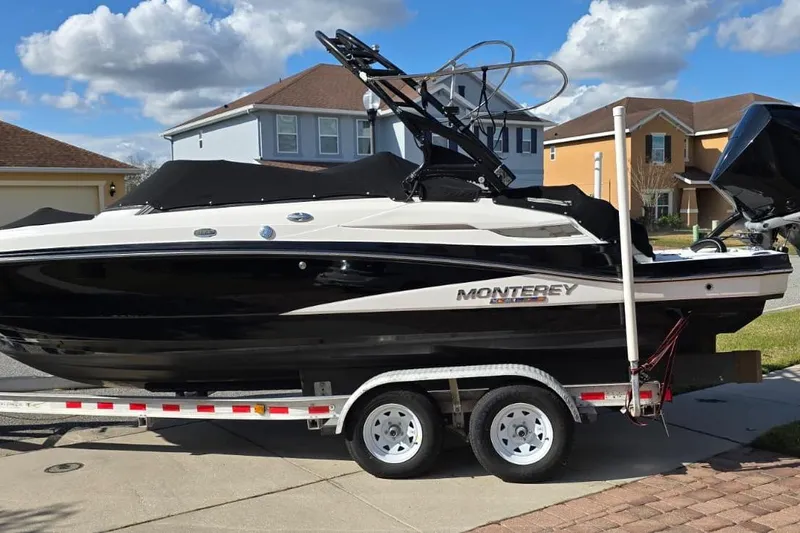 Slide: The Image of 2020 Monterey M-45 boat on trailer, parked in residential area under blue sky. - 28