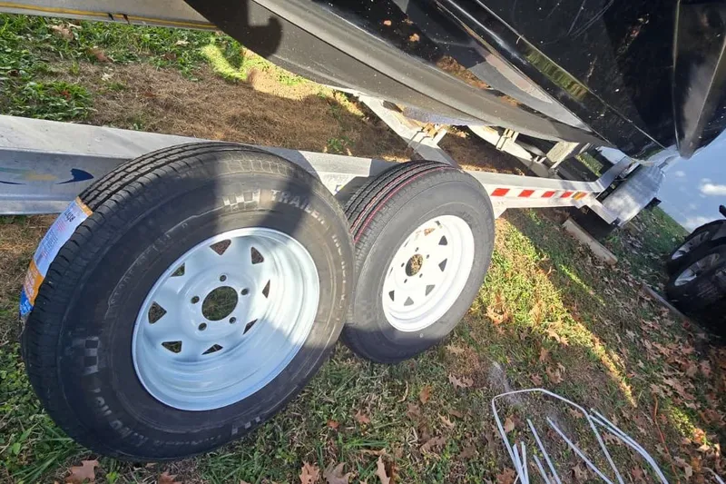 Slide: The Image of Trailer tires on a Monterey M-45 boat trailer, 2020 model, parked on grass. - 31