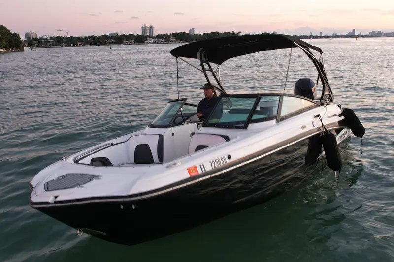 Slide: The Image of 2020 Monterey M-45 boat on calm water at sunset, featuring sleek design and canopy. - 32