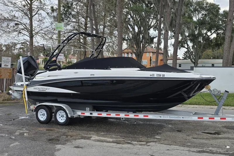 Slide: The Image of 2020 Monterey M-45 boat on trailer, black and white design, parked outdoors. - 9