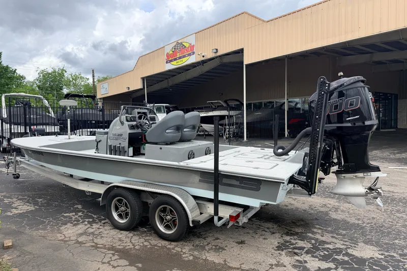Slide: The Image of 2018 SCB Stingray boat on trailer, parked outside dealership under cloudy sky. - 2