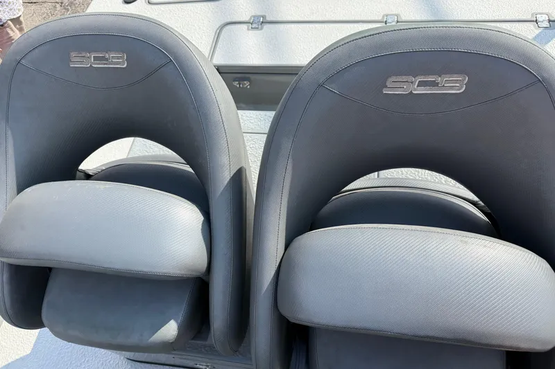 Slide: The Image of Two black SCB Stingray 2018 boat seats with logo, on a textured surface. - 22