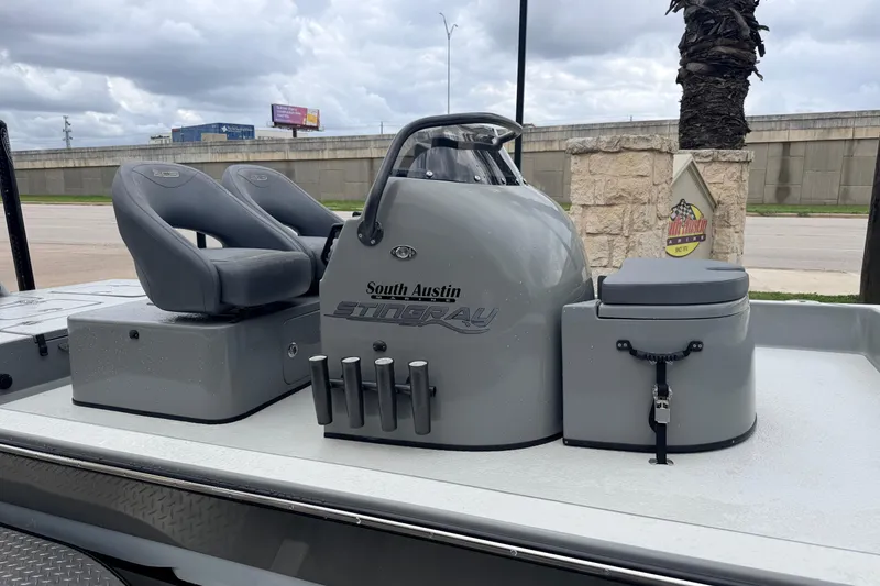 Slide: The Image of 2018 SCB Stingray boat with gray seating and console, parked outdoors. - 6