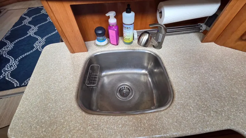 Slide: The Image of Kitchen sink in a 2004 Meridian 459 Motoryacht with cleaning supplies. - 40