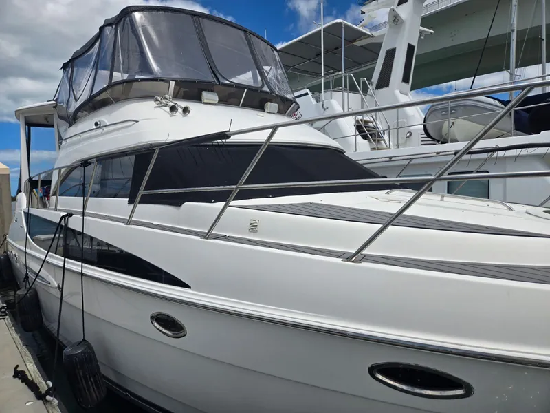 Slide: The Image of 2004 Meridian 459 Motoryacht docked, sleek design, blue sky. - 6
