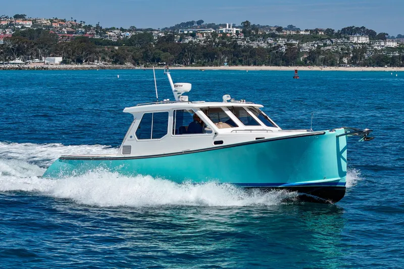 The Image of 2007 True North 38 boat cruising on blue ocean near coastal town. - 0