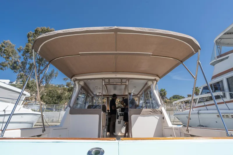 Slide: The Image of 2007 True North 38 boat with canopy, docked under clear blue sky. - 18