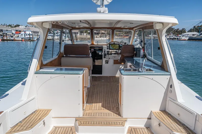 Slide: The Image of 2007 True North 38 boat interior with helm, seating, and kitchenette, docked in a marina. - 23
