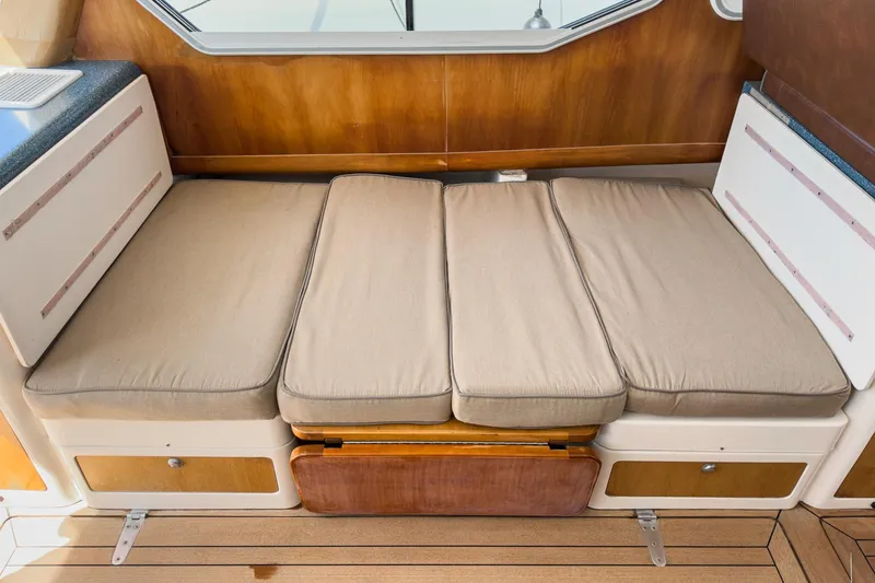 Slide: The Image of Cushioned seating area on a 2007 True North 38 boat, featuring wooden accents and storage compartments. - 33