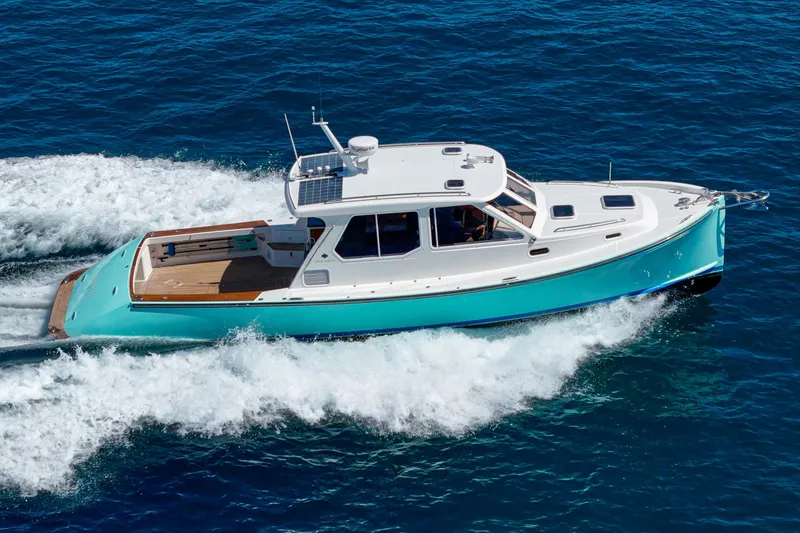 Slide: The Image of 2007 True North 38 boat cruising on blue ocean near coastal town. - 4