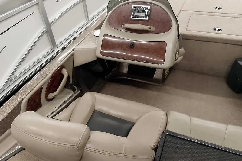 Slide: The Image of 2003 Ranger 521DVX Comanche boat interior with beige seating and wood panel dashboard. - 23