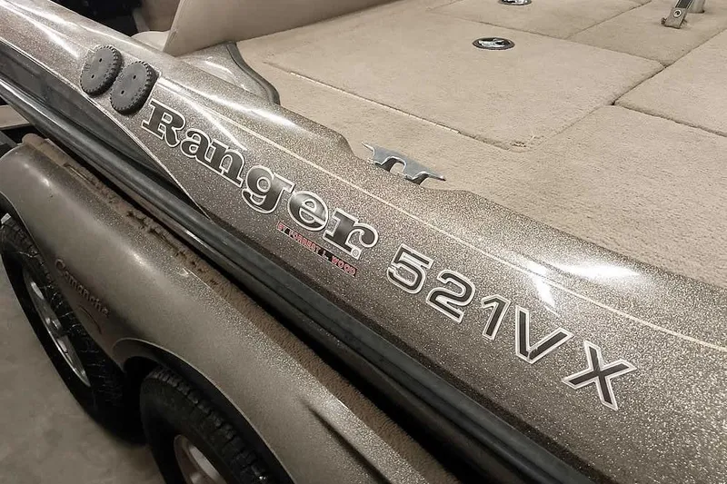 Slide: The Image of 2003 Ranger 521DVX Comanche boat detail with logo and textured surface. - 4