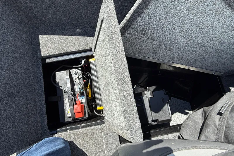 Slide: The Image of 2021 Lund 1650 Rebel XL Sport boat battery compartment with wiring and storage. - 10