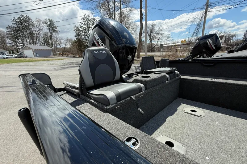 Slide: The Image of 2021 Lund 1650 Rebel XL Sport boat interior with Mercury engine, parked outdoors. - 12