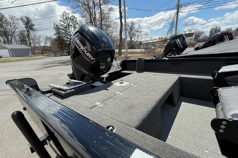 Slide: The Image of 2021 Lund 1650 Rebel XL Sport boat with Mercury outboard motor, parked outdoors. - 13