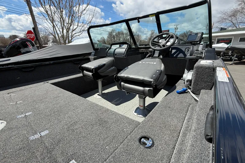 Slide: The Image of 2021 Lund 1650 Rebel XL Sport boat interior with seating and steering console. - 14