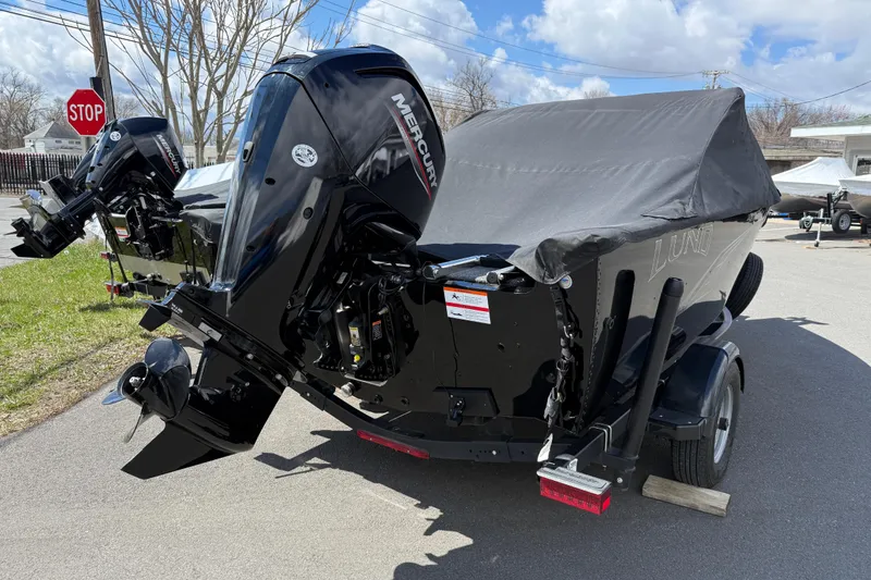 Slide: The Image of 2021 Lund 1650 Rebel XL Sport boat with Mercury outboard motor, covered and parked on a trailer. - 17