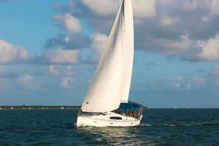 The Image of 2009 Beneteau Oceanis 40 sailing on open water under a partly cloudy sky. - 0