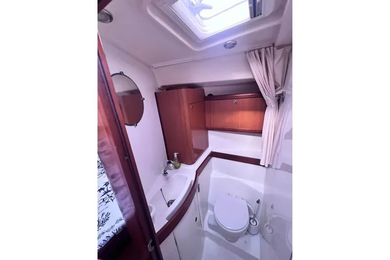 Slide: The Image of Bathroom interior of 2009 Beneteau Oceanis 40 yacht, featuring wood cabinetry and modern fixtures. - 14