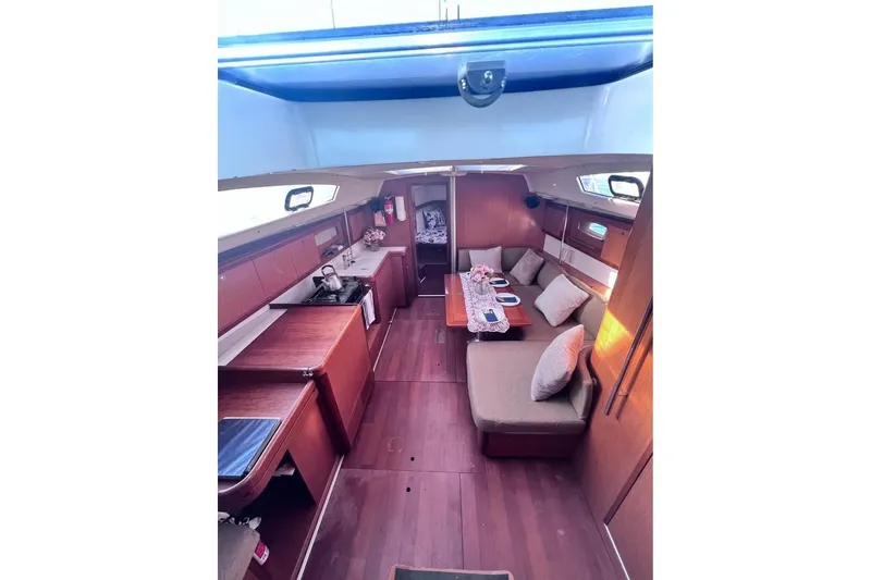 Slide: The Image of Interior of 2009 Beneteau Oceanis 40 sailboat, featuring cozy seating and wooden finishes. - 15