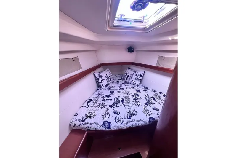 Slide: The Image of Cozy cabin interior of 2009 Beneteau Oceanis 40 sailboat with nautical-themed bedding. - 18