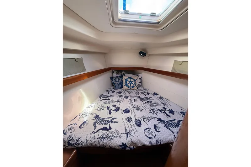 Slide: The Image of Cozy cabin interior of 2009 Beneteau Oceanis 40 sailboat with nautical-themed bedding. - 25