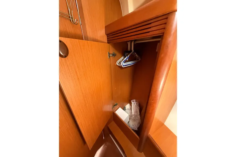 Slide: The Image of Wooden closet interior with hangers in a 2009 Beneteau Oceanis 40 sailboat. - 27
