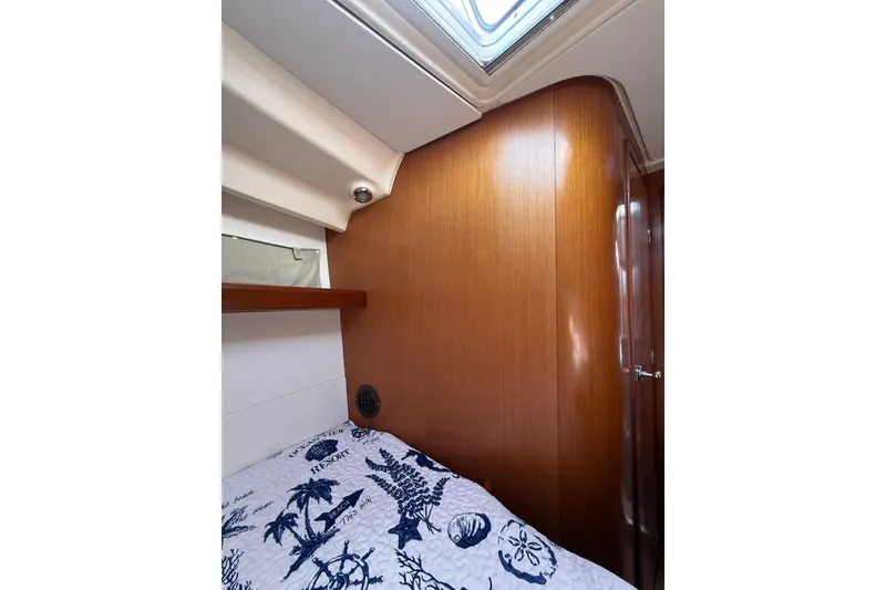 Slide: The Image of Interior cabin of 2009 Beneteau Oceanis 40 yacht with wooden paneling and nautical-themed bedding. - 30