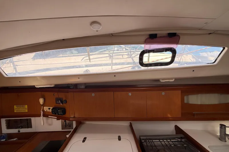 Slide: The Image of Interior view of 2009 Beneteau Oceanis 40 sailboat, featuring wooden cabinetry and a window. - 37