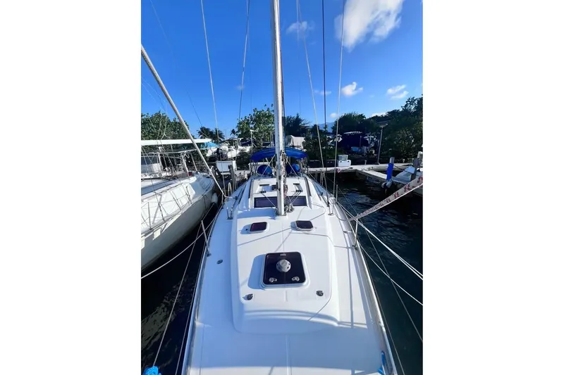 Slide: The Image of 2009 Beneteau Oceanis 40 sailboat docked, showcasing sleek deck design under clear blue sky. - 4