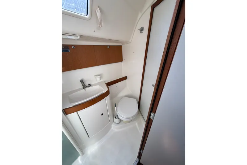 Slide: The Image of 2009 Beneteau Oceanis 40 yacht bathroom with sink, toilet, and wooden cabinetry. - 43