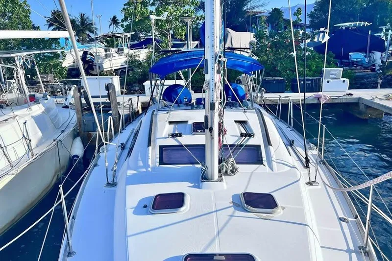Slide: The Image of 2009 Beneteau Oceanis 40 sailboat docked at marina, surrounded by lush greenery. - 5