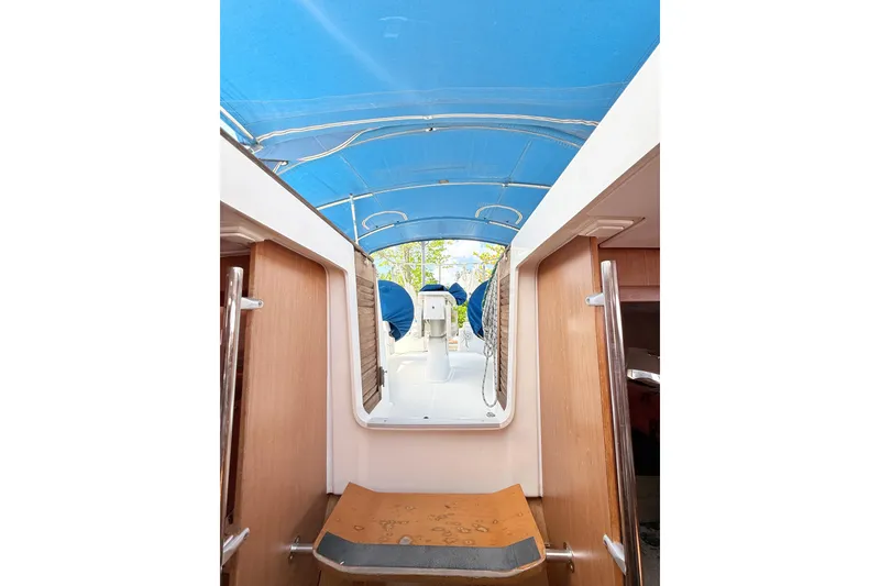 Slide: The Image of Interior view of 2009 Beneteau Oceanis 40 sailboat with blue canopy and wooden accents. - 55