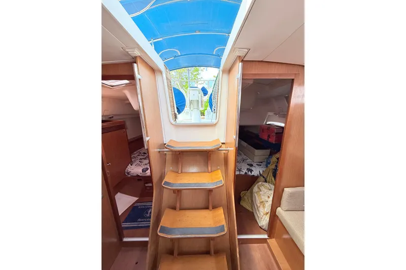 Slide: The Image of Interior view of 2009 Beneteau Oceanis 40 sailboat, featuring wooden steps and cozy cabins. - 56