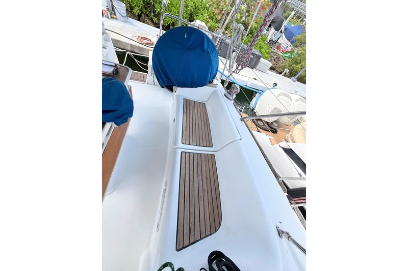 Slide: The Image of 2009 Beneteau Oceanis 40 sailboat deck with wooden panels and blue covers. - 57