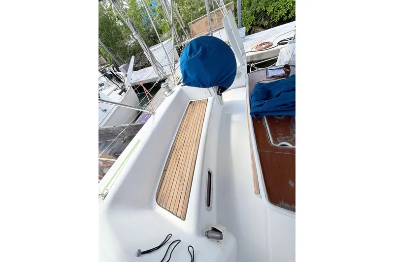 Slide: The Image of 2009 Beneteau Oceanis 40 sailboat deck with blue cover and wooden seating area. - 58