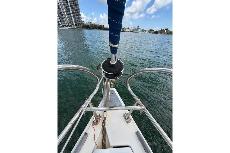 Slide: The Image of Bow view of 2009 Beneteau Oceanis 40 sailboat on water, with cityscape background. - 63