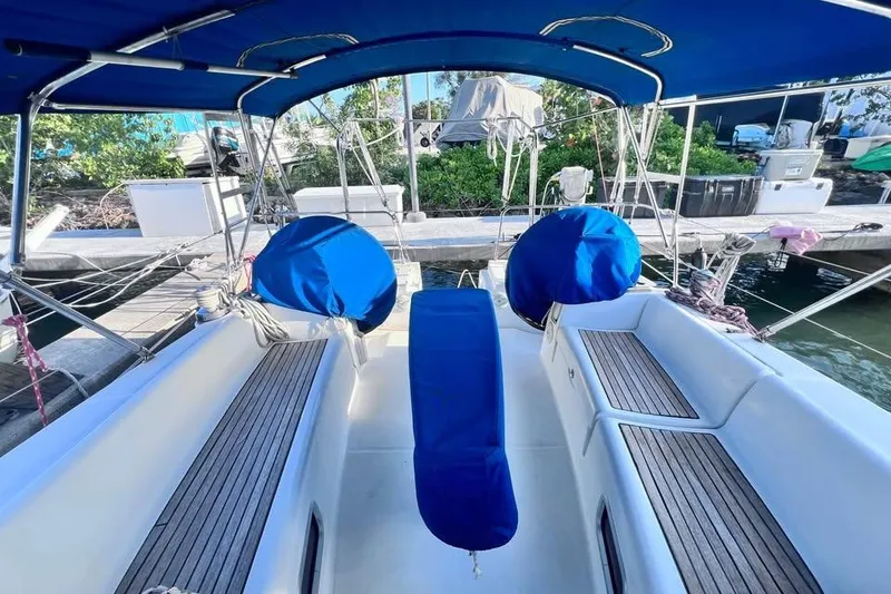 Slide: The Image of 2009 Beneteau Oceanis 40 sailboat cockpit with blue covers and wooden seating. - 7