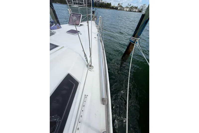 Slide: The Image of 2009 Beneteau Oceanis 40 sailboat docked by the water, showcasing deck and railing. - 70