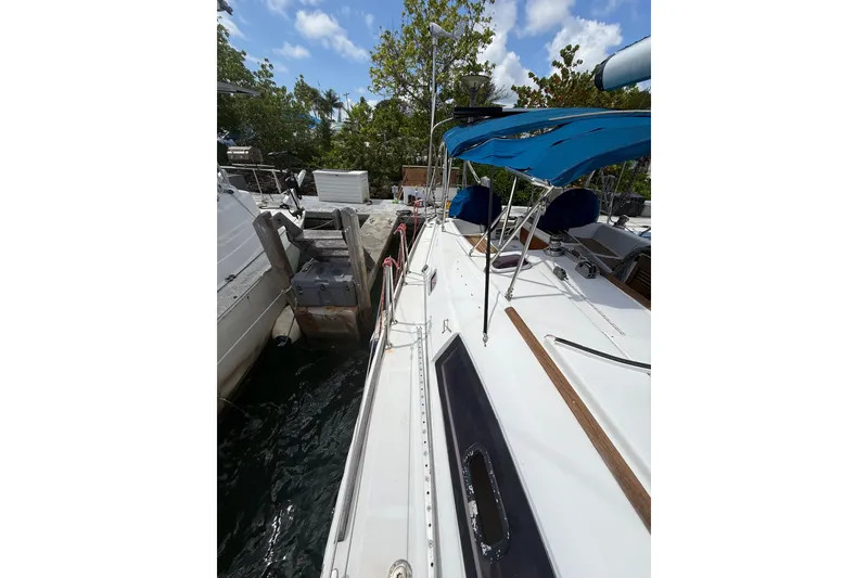 Slide: The Image of Beneteau Oceanis 40 sailboat docked, featuring blue canopy and sleek white deck, 2009 model. - 72